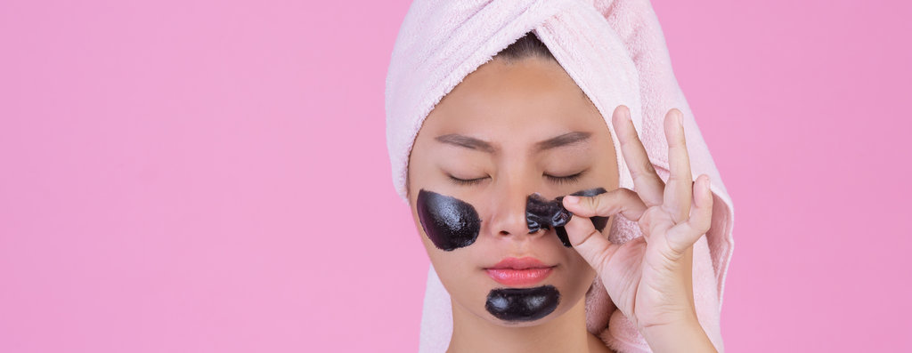 Beauty cosmetic peeling. Young female with black peel off mask o