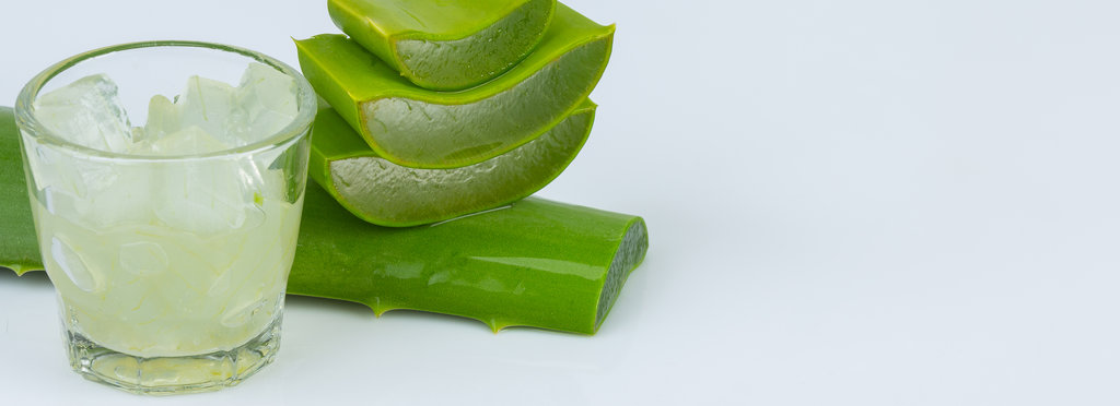 Jel of aloe vera in a glass with aloe vera leave is near togethe
