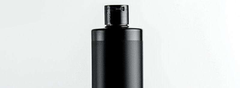 front view black plastic bottle from under shampoo with a pink strip