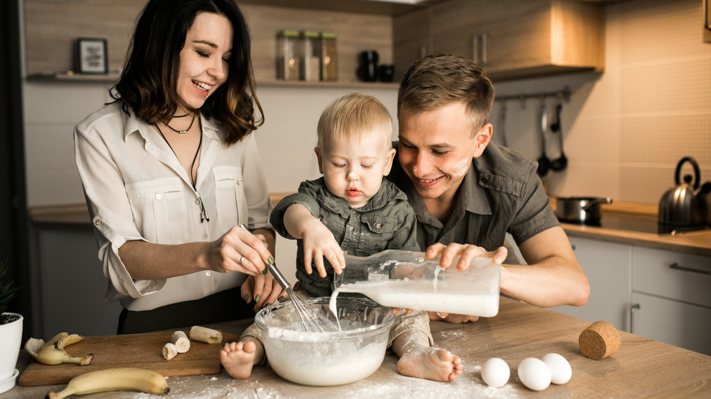 toddler and his parents baking in the kitchen
