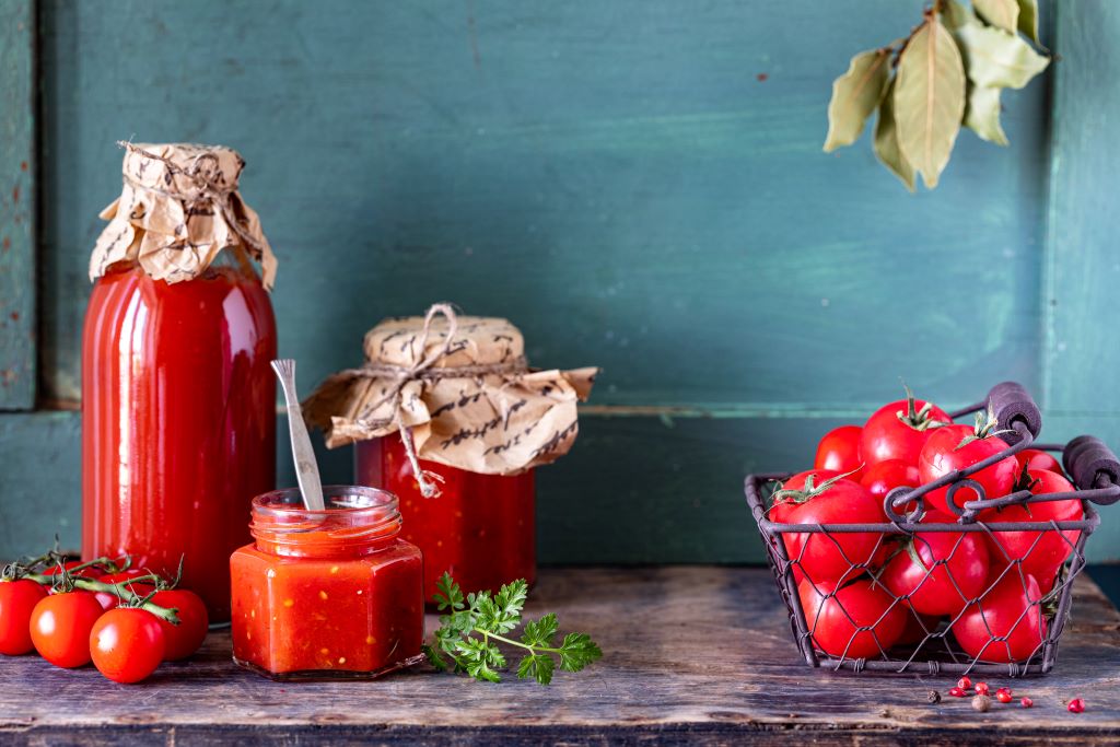 homemade-tomato-ketchup-made-from-ripe-red-tomatoes-glass-jars-with-ingredients-old-wooden-table homemade tomato puree
